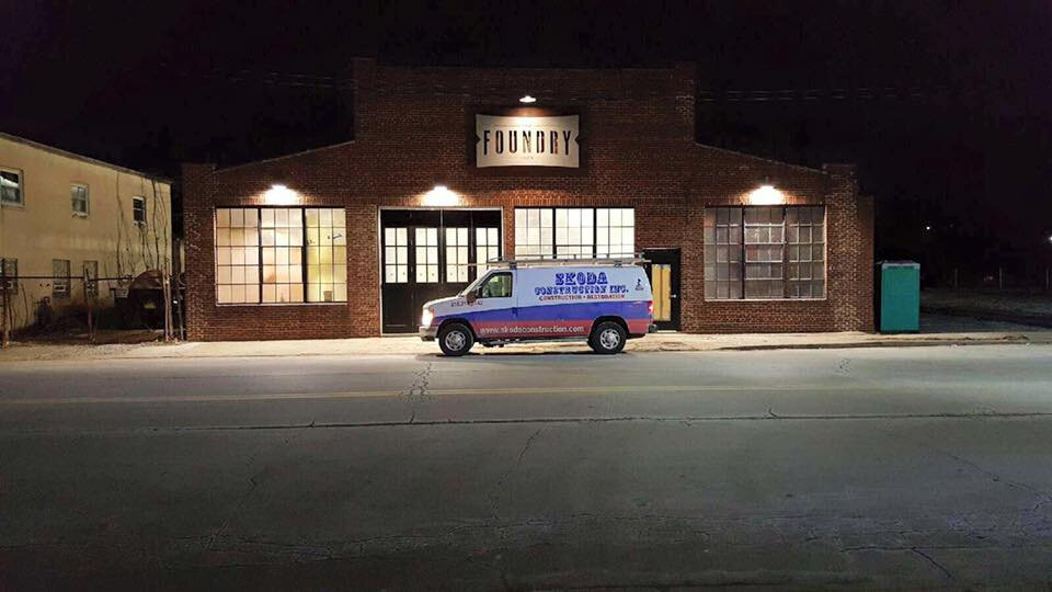 The Foundry brick exterior at night with illuminated signage and Skoda Construction van — commercial renovation project in Northeast Ohio