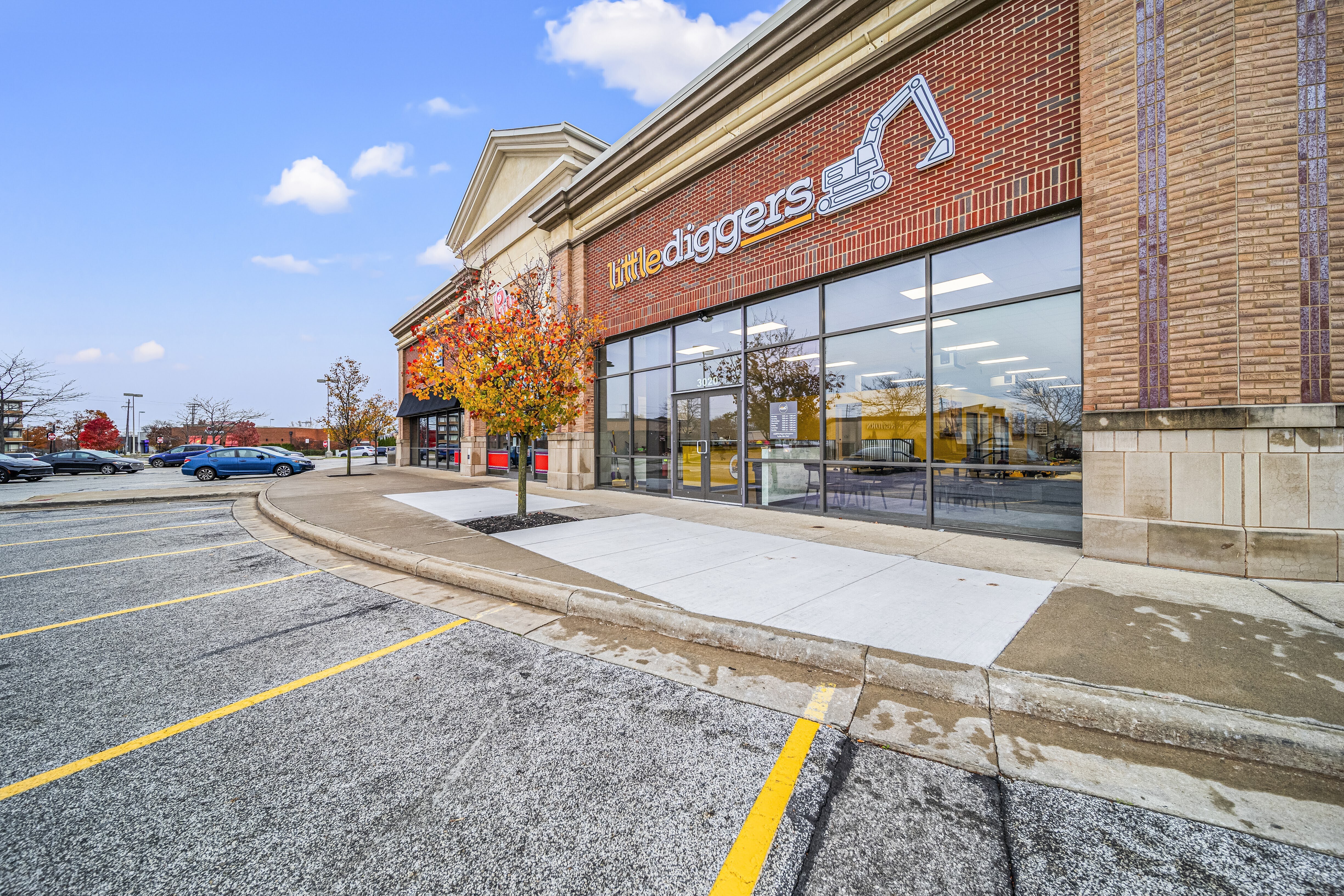 Open-plan glass office suite with wood accent panels and modern workstations — commercial office construction by Skoda Construction, Northeast Ohio