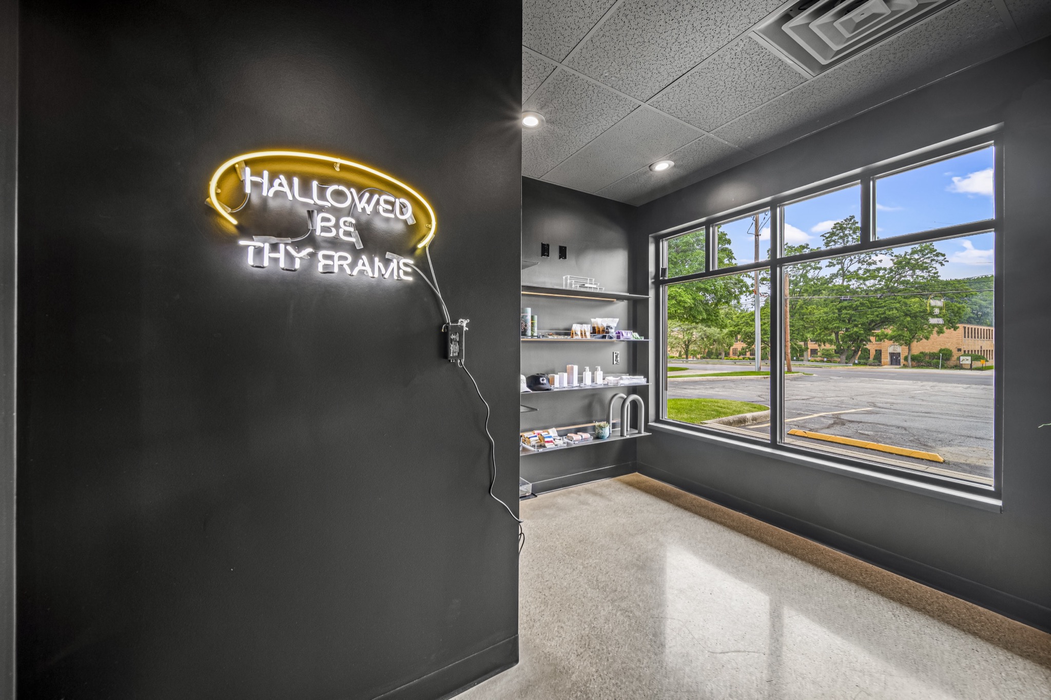 Custom neon signage and built-in product shelving in luxury fitness studio retail area — commercial interior by Skoda Construction, Northeast Ohio