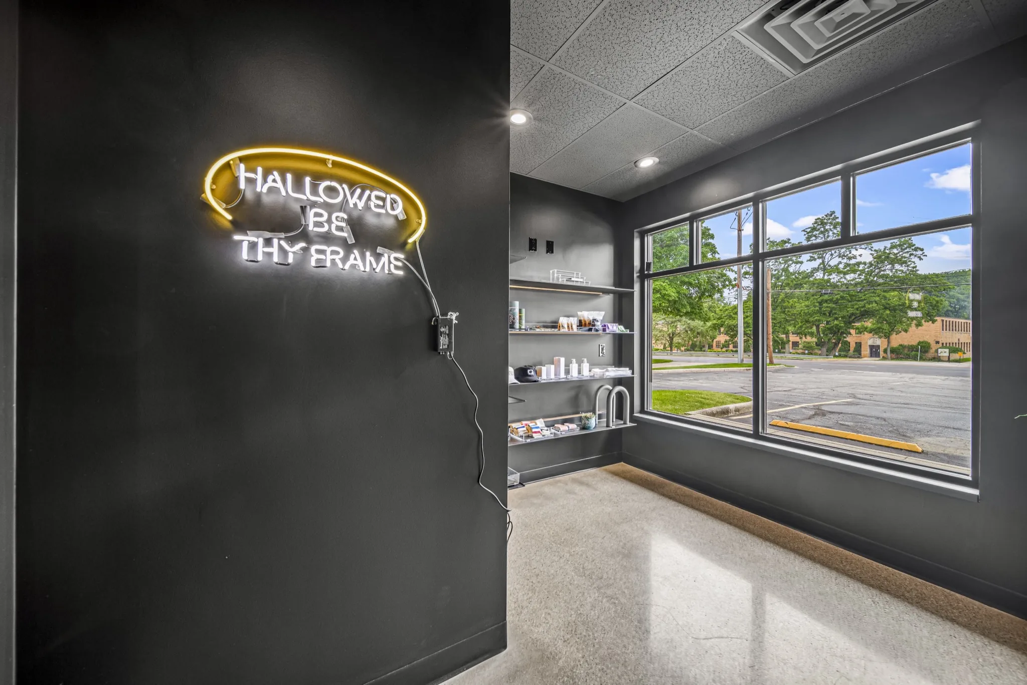 Custom neon signage and built-in product shelving in luxury fitness studio retail area — commercial interior by Skoda Construction, Northeast Ohio