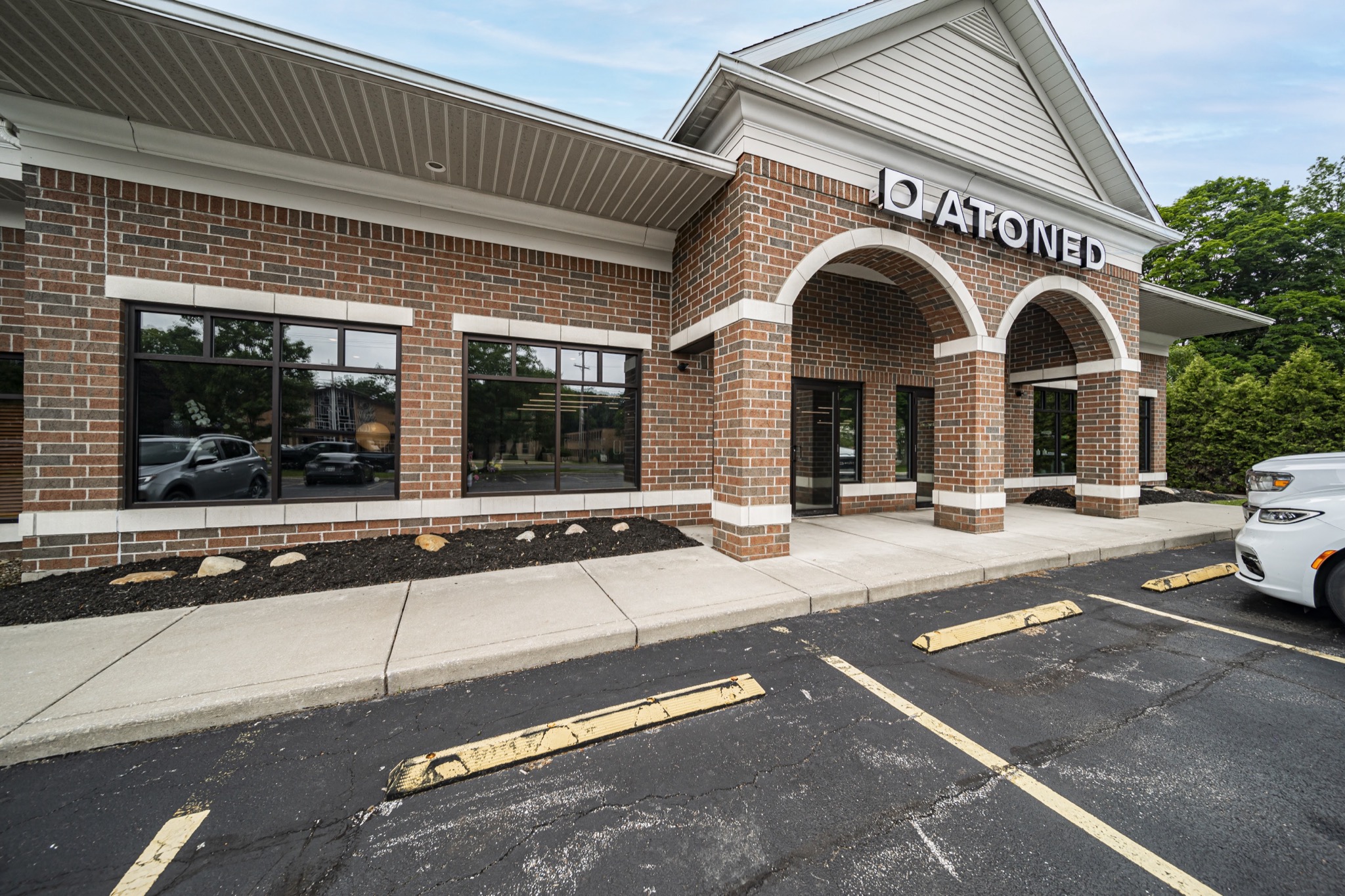 Commercial fitness studio brick exterior with arched entryway and signage — commercial construction by Skoda Construction, Northeast Ohio