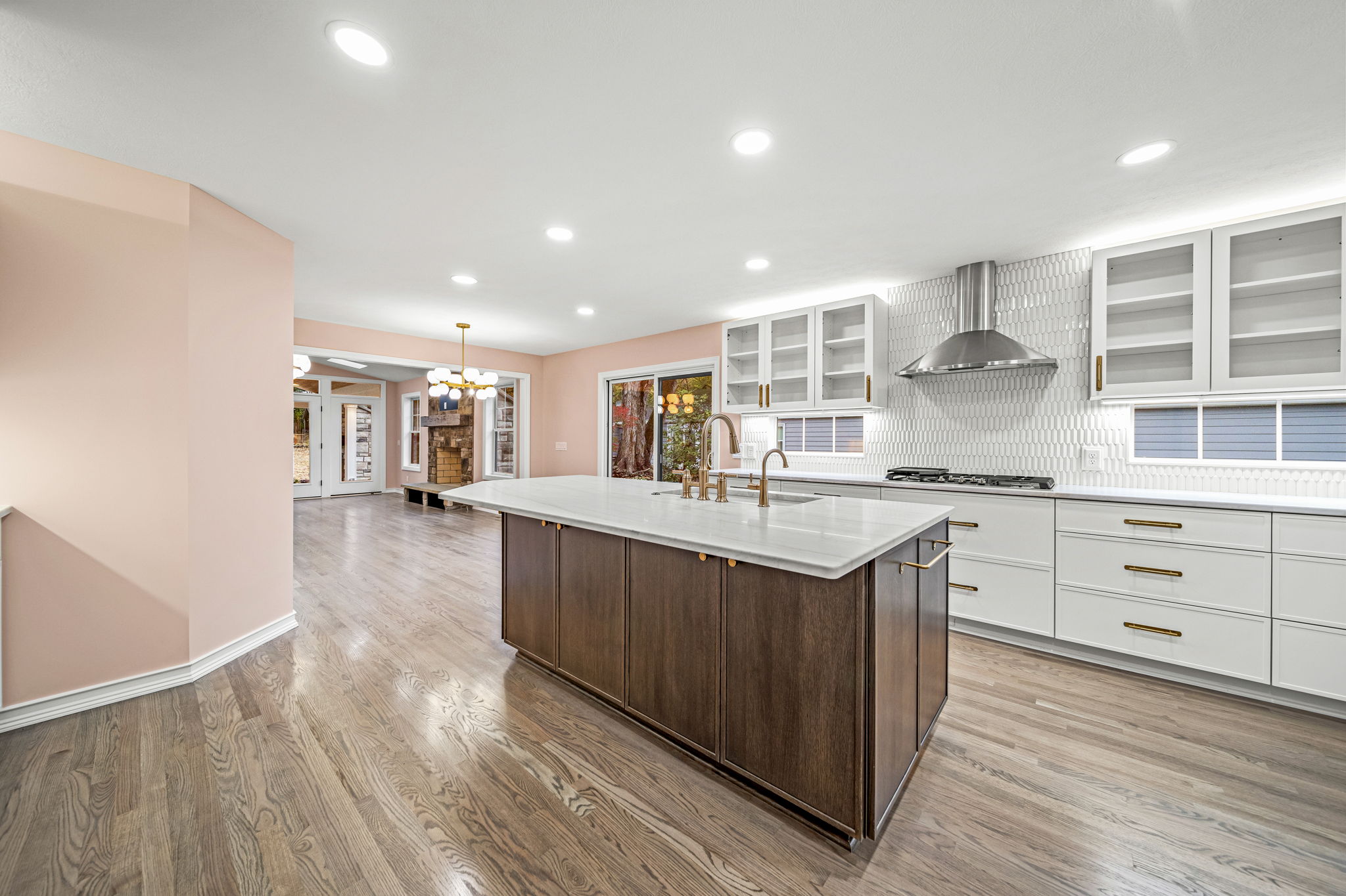 Expansive modern farmhouse kitchen with walnut island, white quartz countertops, brass hardware, and herringbone backsplash — new construction by Skoda Construction, Northeast Ohio