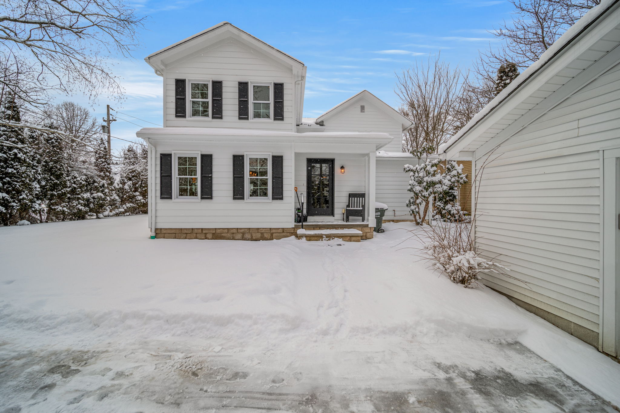 Classic colonial rear entry with covered porch and stone foundation after whole-home renovation — Skoda Construction, Northeast Ohio