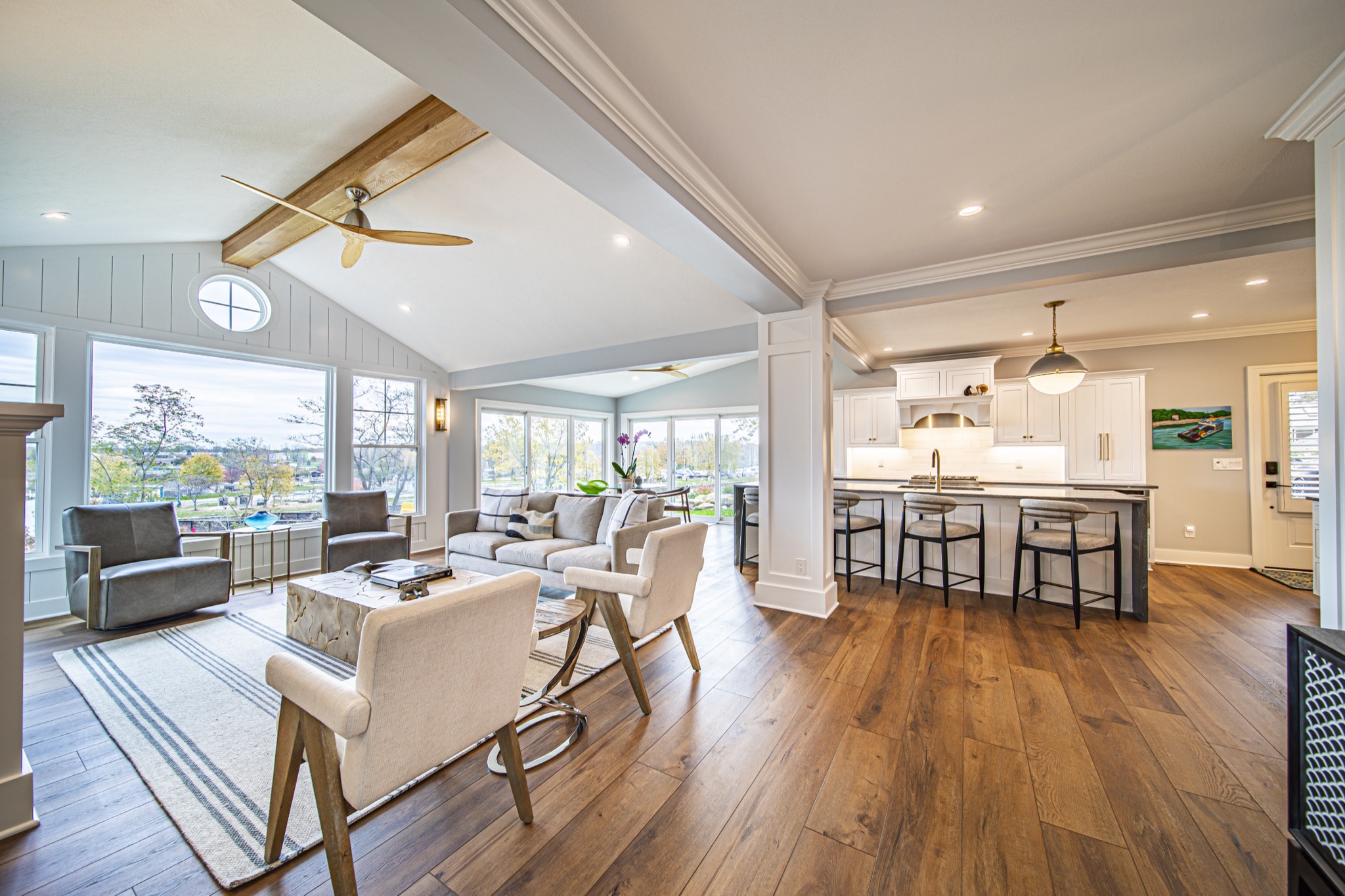 Wide-angle open floor plan with vaulted beam ceiling, living room, and kitchen island — luxury farmhouse by Skoda Construction, Northeast Ohio