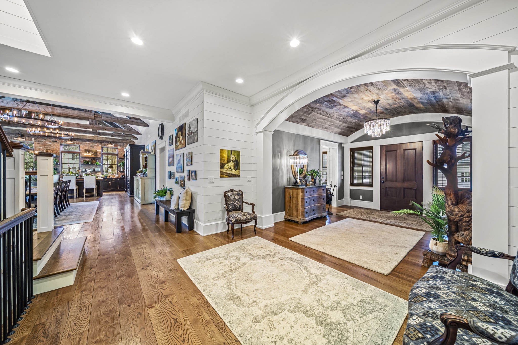 Central hallway with shiplap walls, reclaimed wood barrel-vault entry, and open sightlines to kitchen and great room — custom home by Skoda Construction, Northeast Ohio