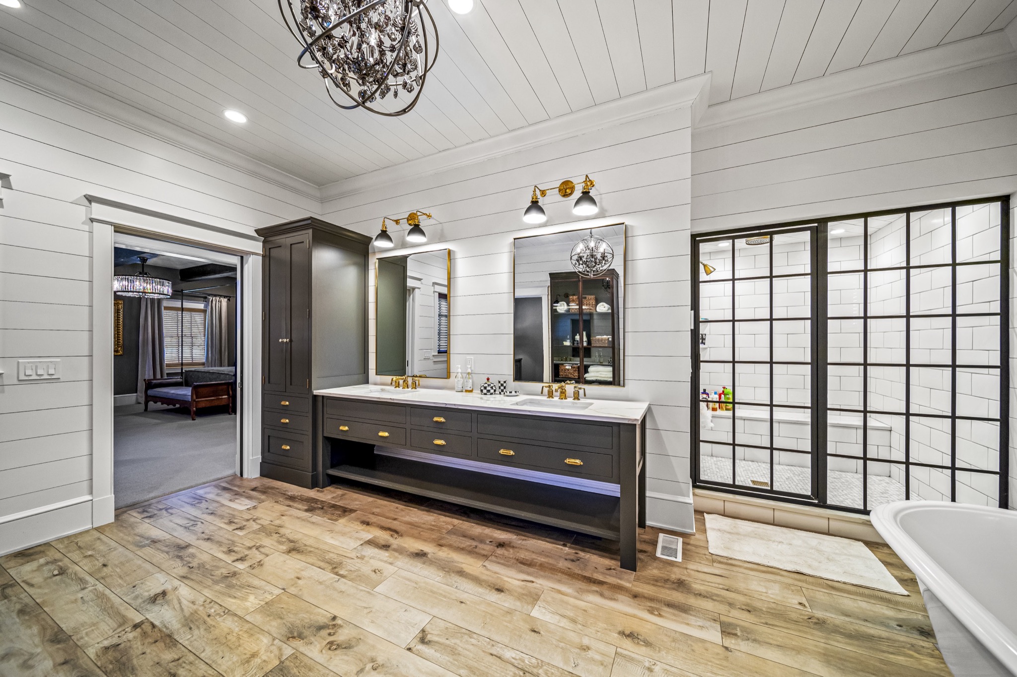 Master bathroom vanity wall with floating double vanity, LED accent lighting, industrial-style glass shower, and shiplap throughout — luxury home by Skoda Construction, Northeast Ohio