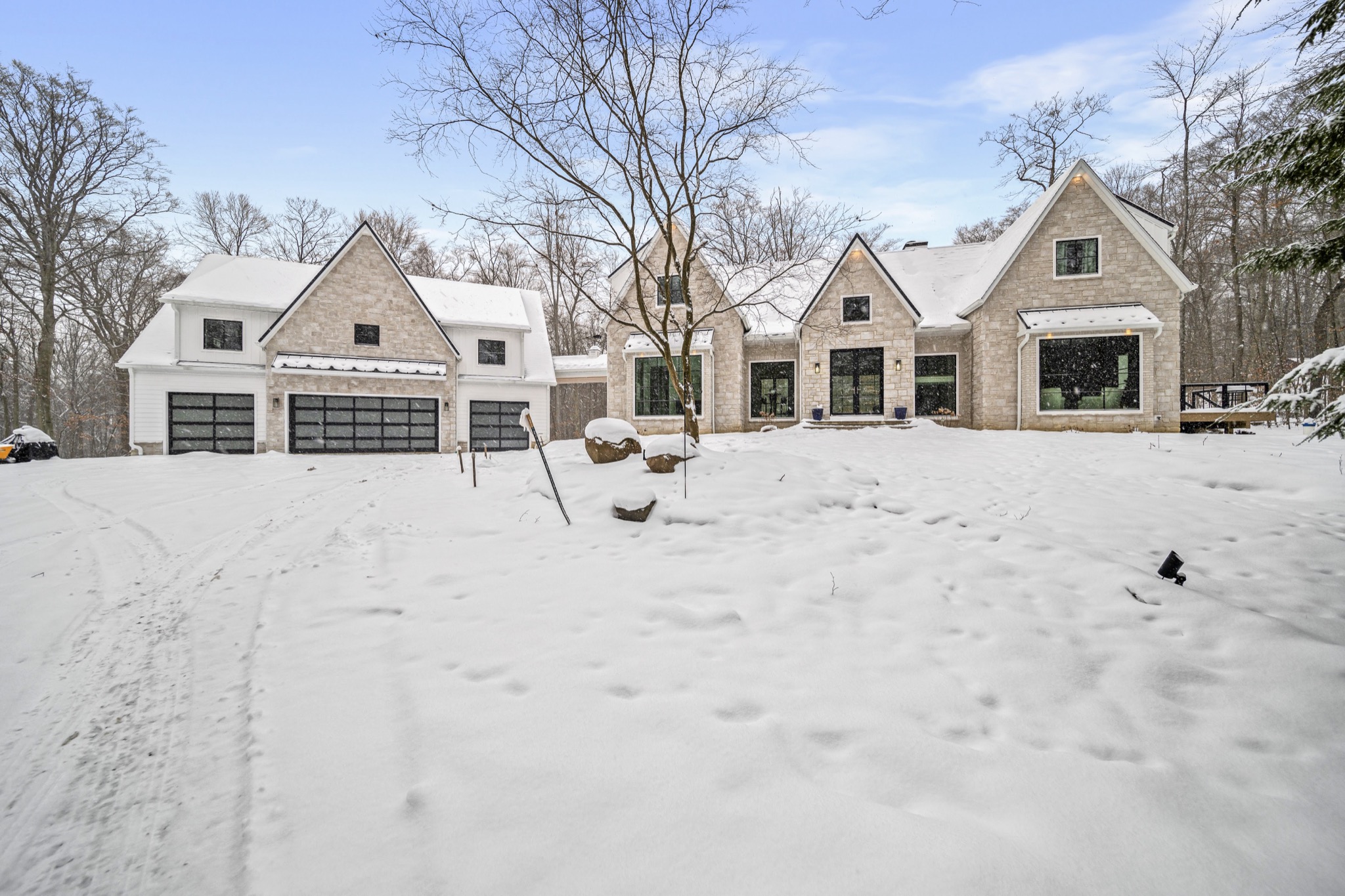 Contemporary estate with stone facade — custom home by Skoda Construction