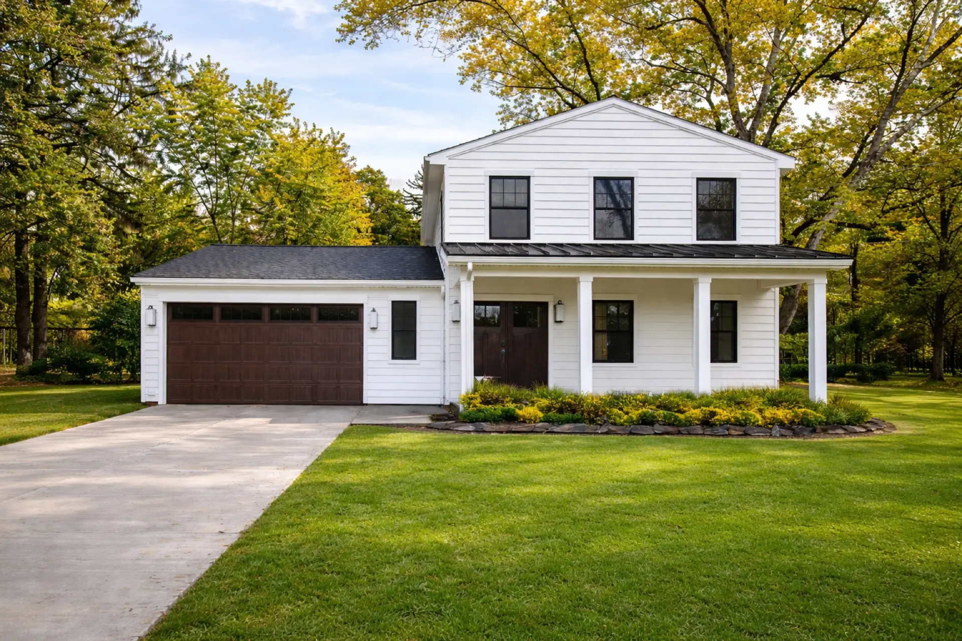 Custom white farmhouse with dark garage doors — Skoda Construction, Chagrin Falls