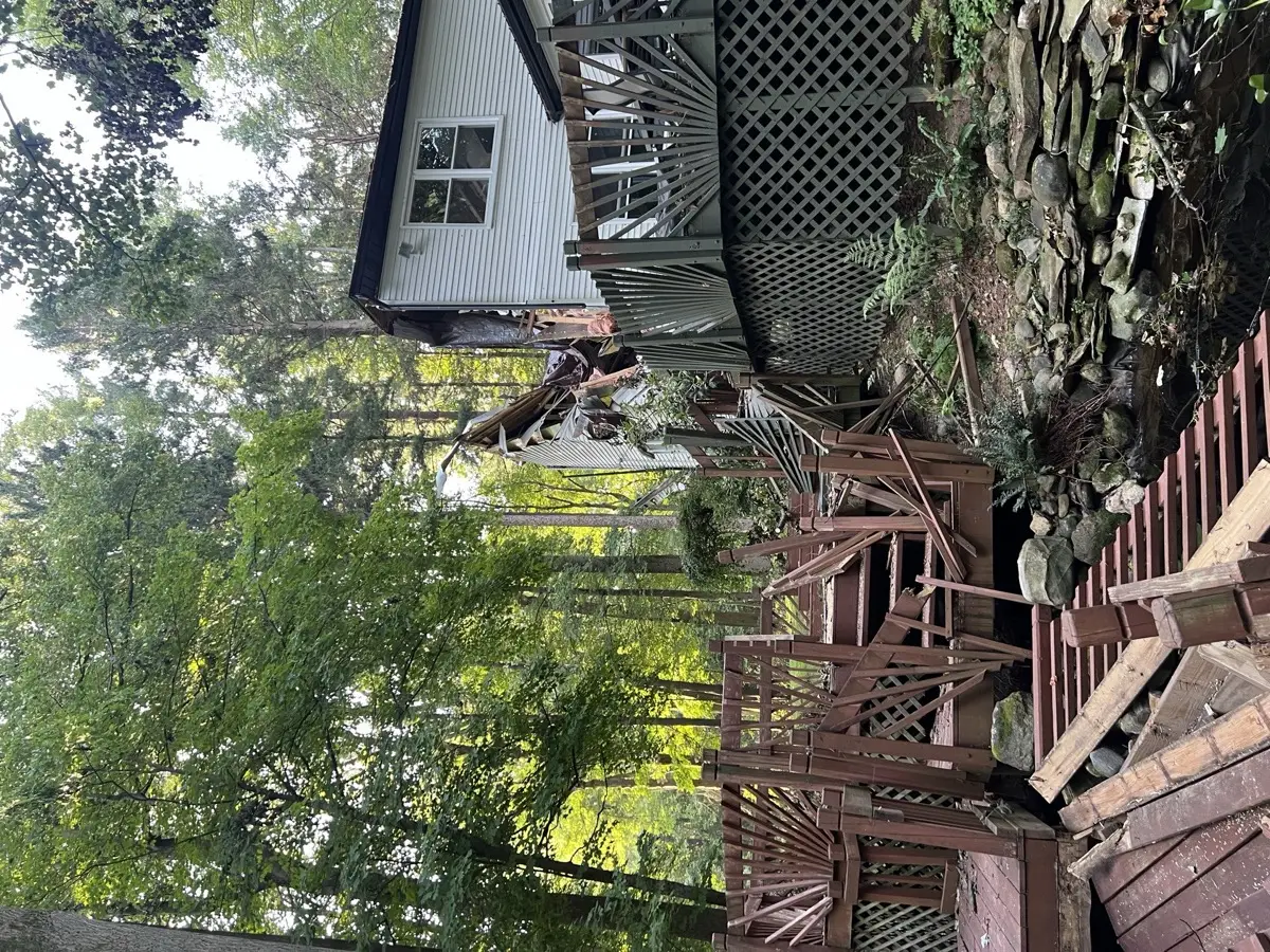 Luxury custom estate with standing-seam metal roof, stone and board-and-batten facade, covered entry porch, and three-car garage — custom home by Skoda Construction, Northeast Ohio